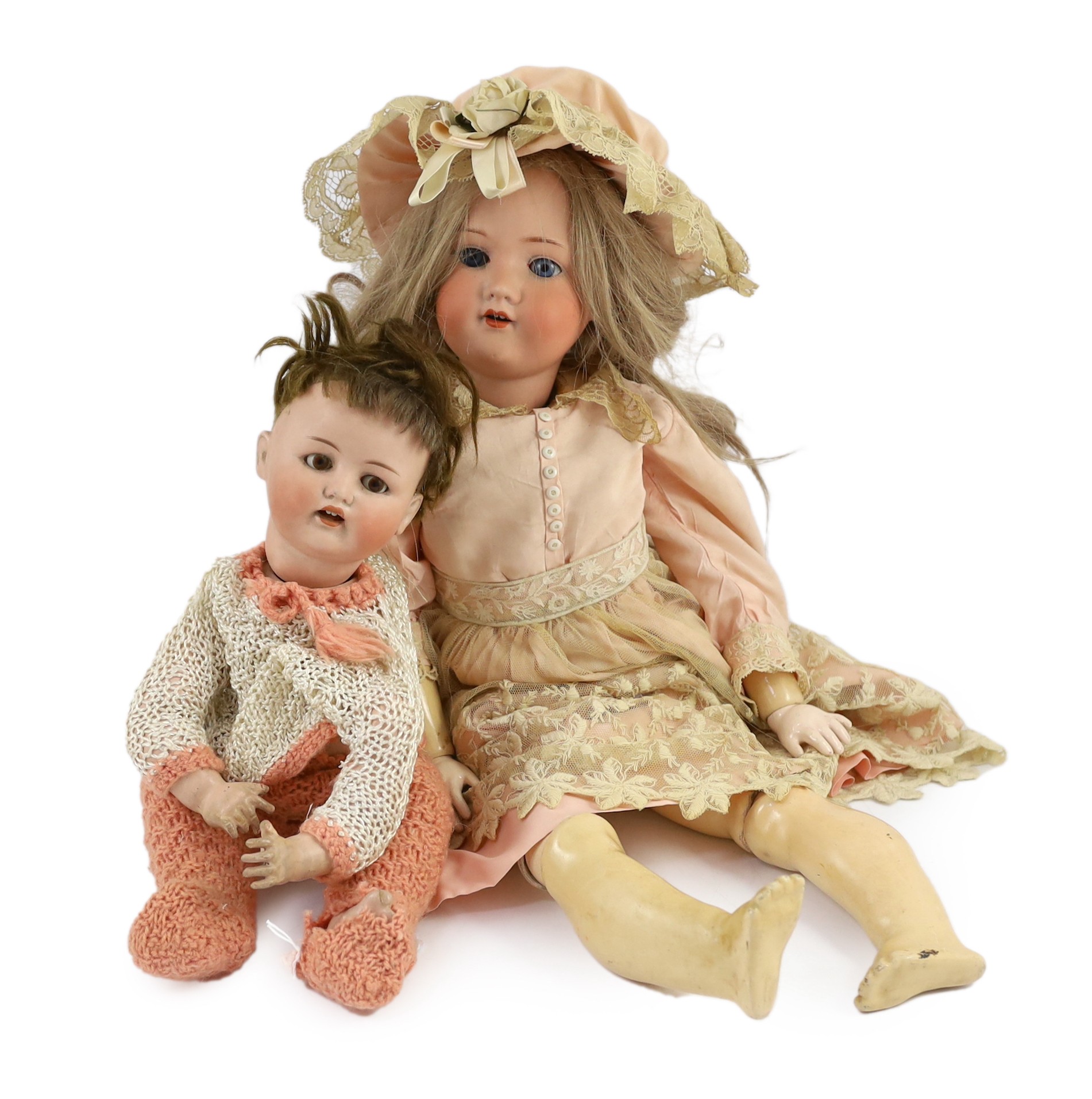 An Armand Marseille bisque doll, mould 390 with sleeping eyes and open mouth, jointed wood and composition body, cream and lace dress and matching bonnet, 22in., and a German Bebe Elite bisque doll